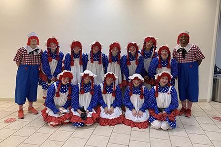 A group of students pose in Raggedy Ann and Raggedy Andy costumes.