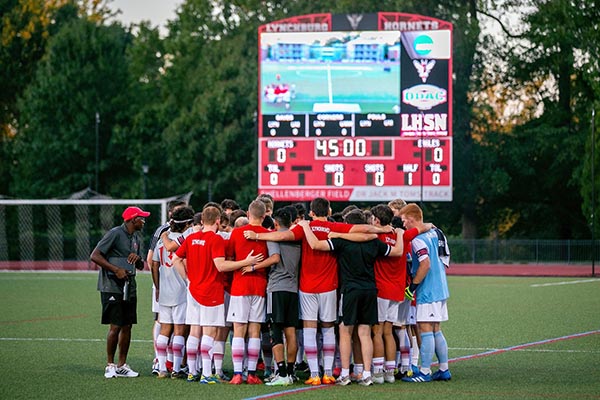 The soccer team huddles during a fall 2022 game on Shellenberger Field