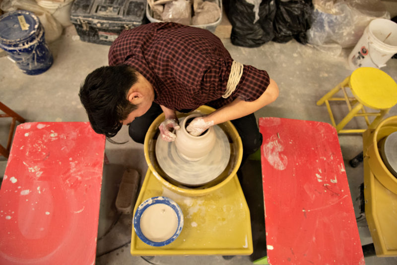 Dr. Bosco Bae making pottery.