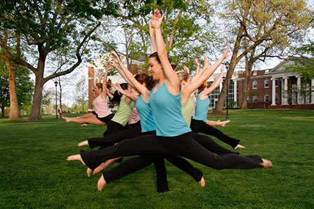 a group of women dance outside on campus