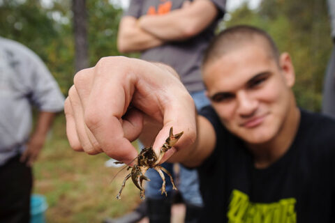 A student holding a crawdad during a biology class at Claytor Nature Center