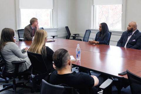 A professor in a conference room is talking to his students