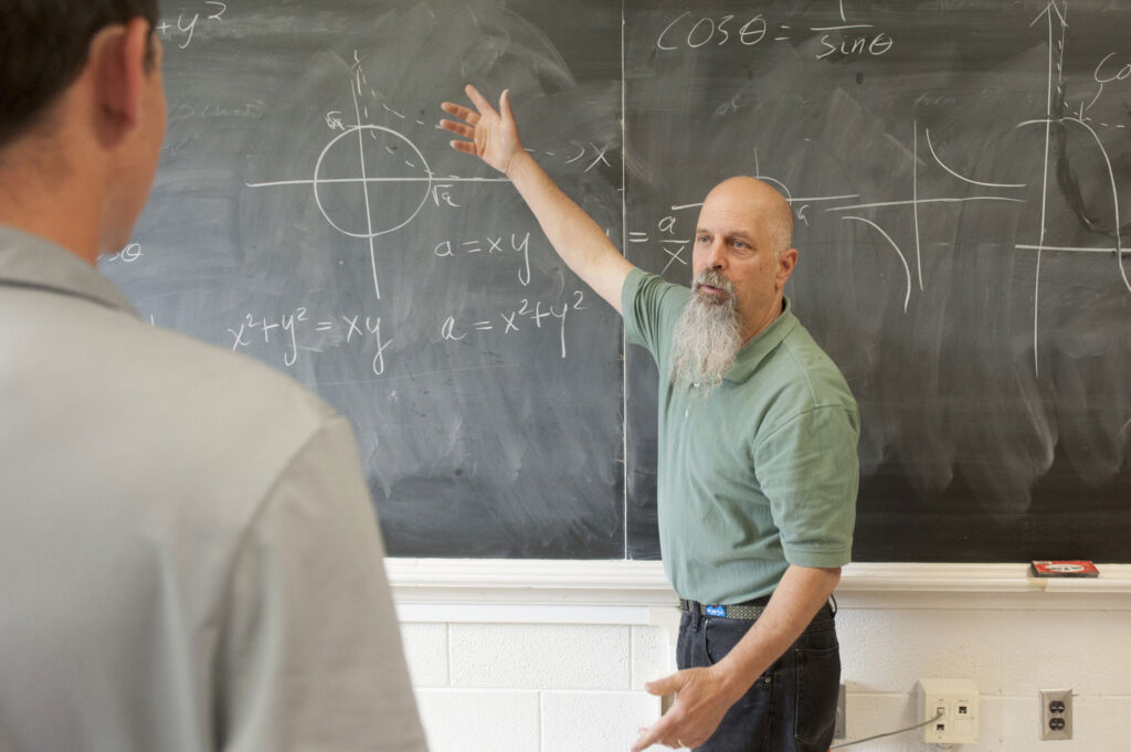 Dr. Peterson teaching at a chalk board.