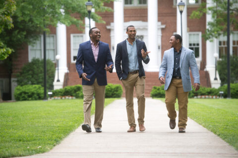Three Master of Business Administration (MBA) students walk across campus.