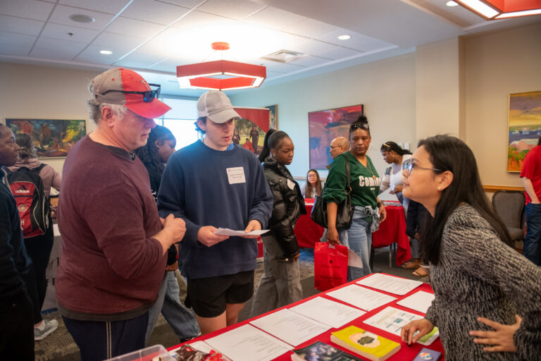 Professor Ei Hlaing talks with a parent and his son at Discovery Weekend