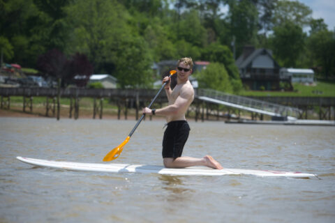 a man kneeling on a paddle board