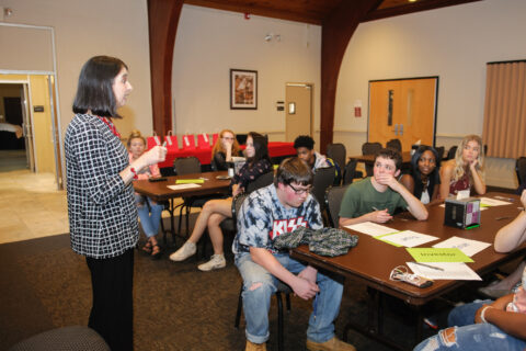 Students look at a teacher while they speak
