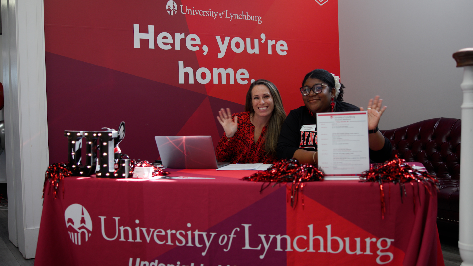 Staff wave to the camera in the Admissions building.