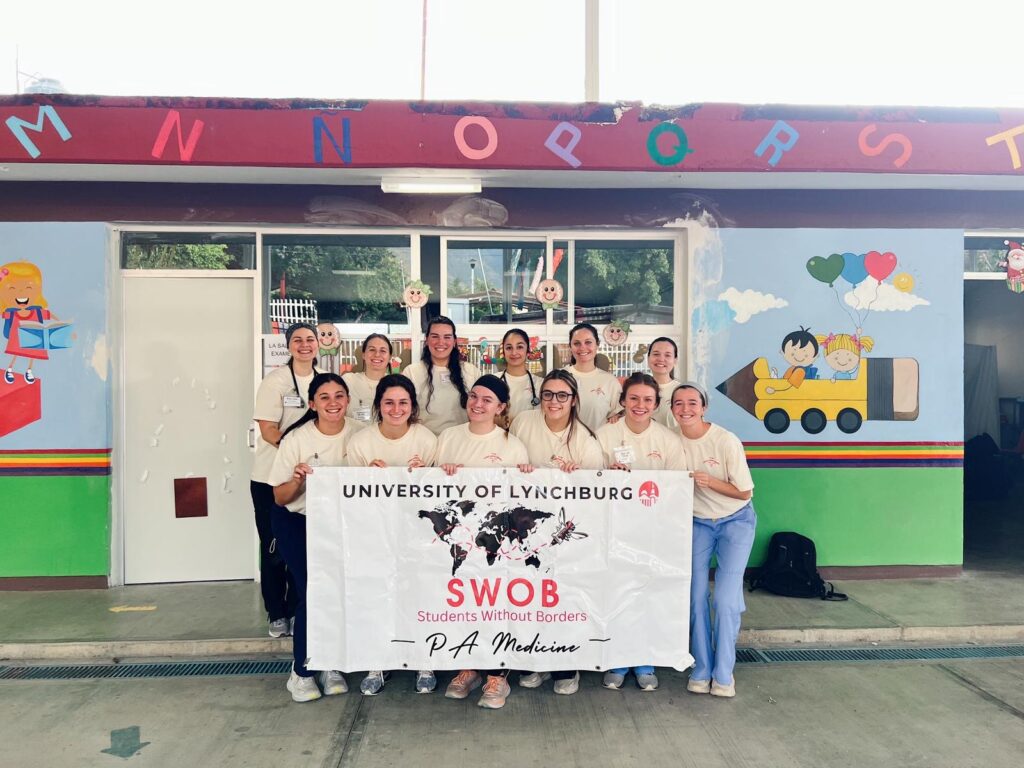 A group of students pose with a sign.
