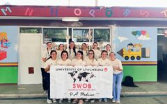 A group of students pose with a sign.