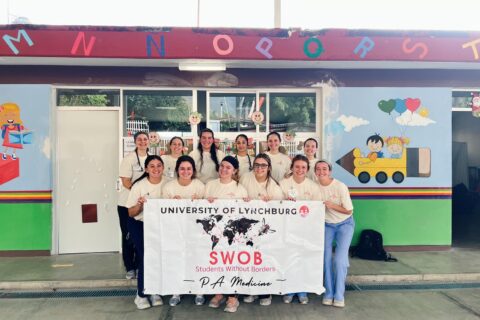 A group of students pose with a sign.