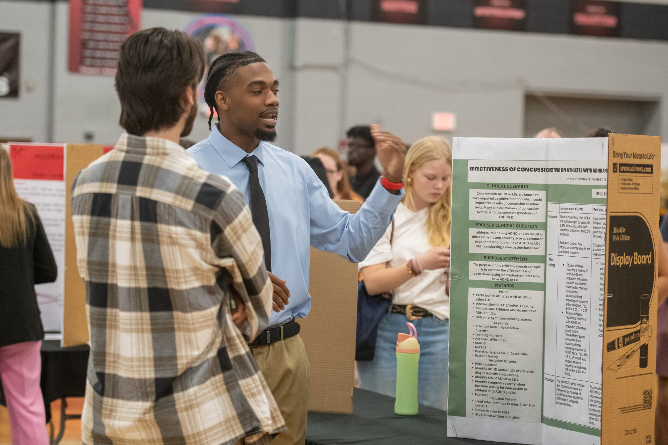 Student presenting a poster presentation in Turner Gym during Student Scholar Showcase.
