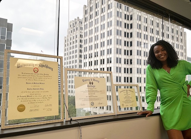 Justice Gray stands with her diplomas.