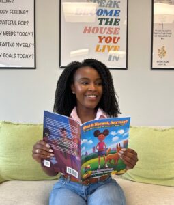 Justice Gray holding her children's book, “What is Normal, Anyway?: Because the Best Kind of Normal is Being You”