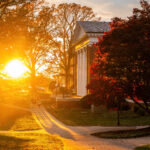 The sun shining through the trees beside Hopwood Hall