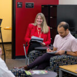 Christine Harriger, Jeffery Reason, chat in CEO office while taking notes.