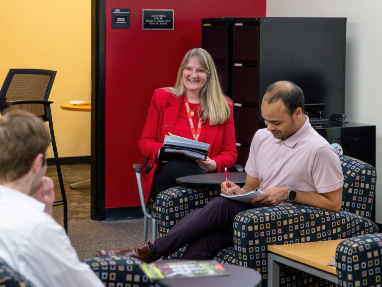 Christine Harriger, Jeffery Reason, chat in CEO office while taking notes.