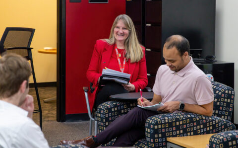 Christine Harriger, Jeffery Reason, chat in CEO office while taking notes.