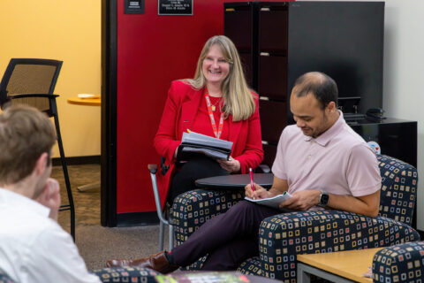 Christine Harriger, Jeffery Reason, chat in CEO office while taking notes.
