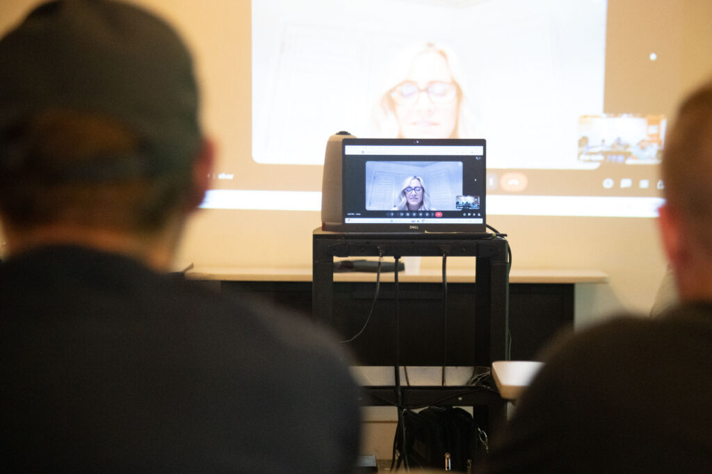 Two student listen to an online presentation.