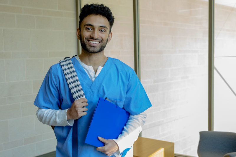 Healthcare admin student posed with a laptop