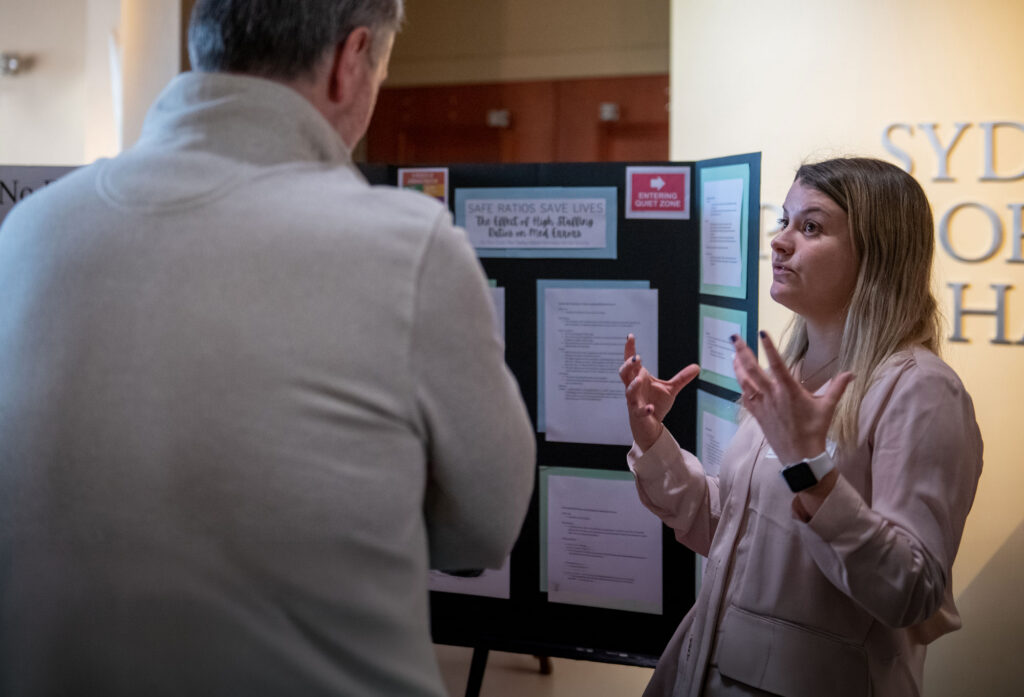 Student talking to a faculty member are a presentation.