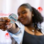 Woman holding an "I gave!" sticker
