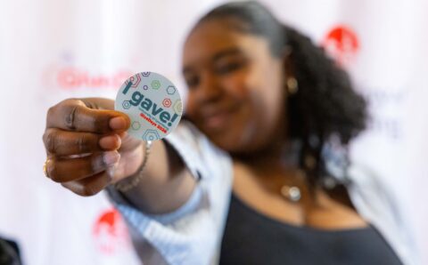 Woman holding an "I gave!" sticker