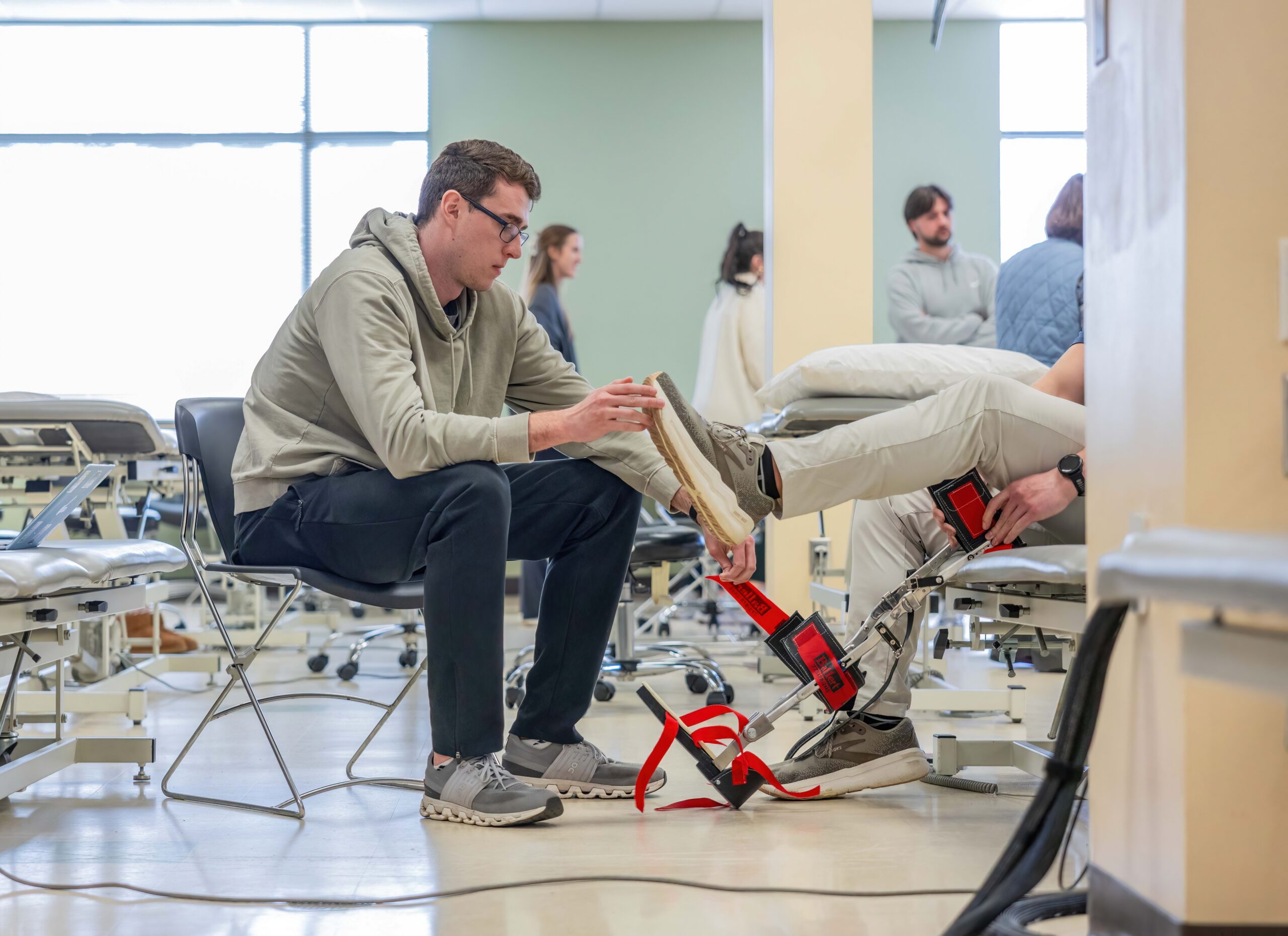 male DPT student working on the foot of a patient in a lab