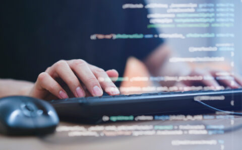 close up programmer student man hand typing on keyboard at computer desktop to input code language into software for study bug and defect of system in classroom , development of technology concept