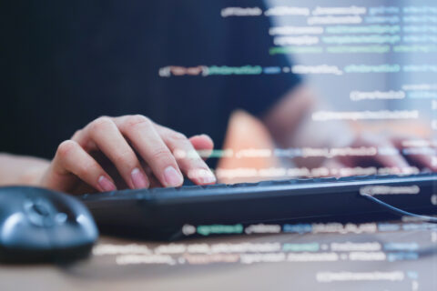 close up programmer student man hand typing on keyboard at computer desktop to input code language into software for study bug and defect of system in classroom , development of technology concept
