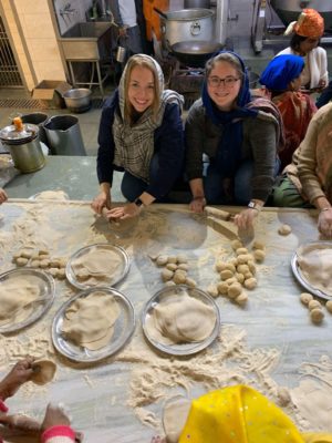 Dr. Jamie Brooks ’08, ’23 MPH, assistant professor of biology (left), and Madysen Buckley ’23 help make bread at Gurudwara Bangla Sahib, a Sikh temple in New Delhi.