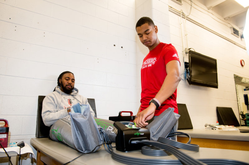 Julius Murphy ’19 MSAT (right) works in the training room as a student at Lynchburg.
