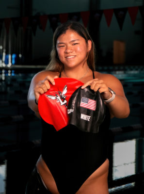 Mei White '26 displays her Lynchburg and Team USA swim caps.