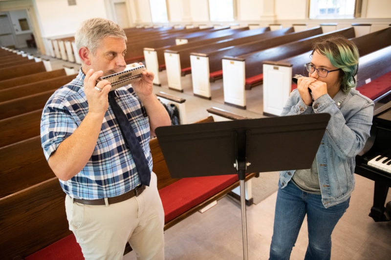 Dr. George Miklas and Sam Lipert '23 play harmonica together.