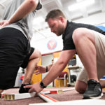C.J. Rosenborough guides an athlete's ankle and leg in a procedure that measures range of motion