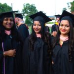 Three women of color in graduation caps and gown