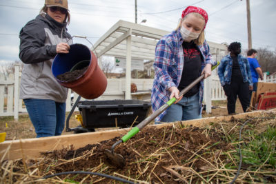 Volunteers work on beds at the community garden outside the Calloway Store building on Pierce Street in Lynchburg.