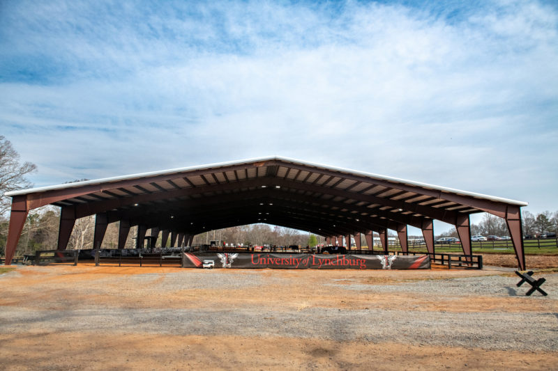 Covered riding arena under blue skies