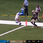 A football player performs a front flip to land in the end zone for a touch down.