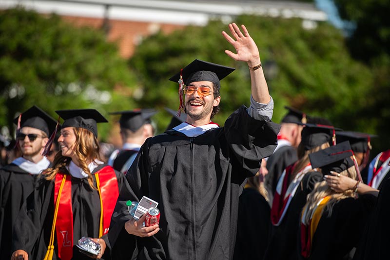 A graduate waves to friends and family at the 2024 Commencement exercises.