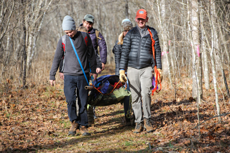 Students in an Outdoor Leadership Programs Wilderness First Aid class practice carrying an injured person. Photo by Nat LeDonne ’18. 