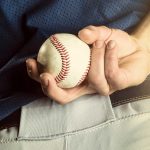 Baseball pitcher holding a ball.