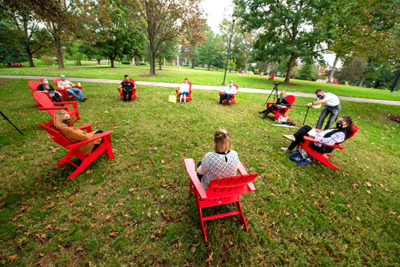 a group of faculty, staff, and students discuss diversity in red chairs on the Dell