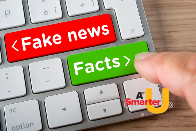 A keyboard with a red button that says "fake news" and a green button that says "facts"