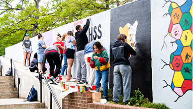 Students painting a wall.
