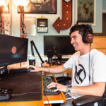 Landon Hammerley wearing headphones and using his computer in his room