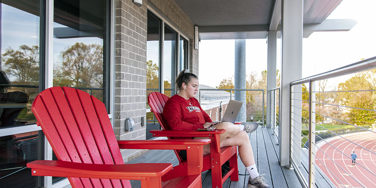 A student studies on the balcony of Westover Hall