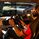 Jay Salmon sits in an iRacing rig and drives on a virtual racetrack