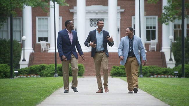 Three Master of Business Administration (MBA) students walk across campus.